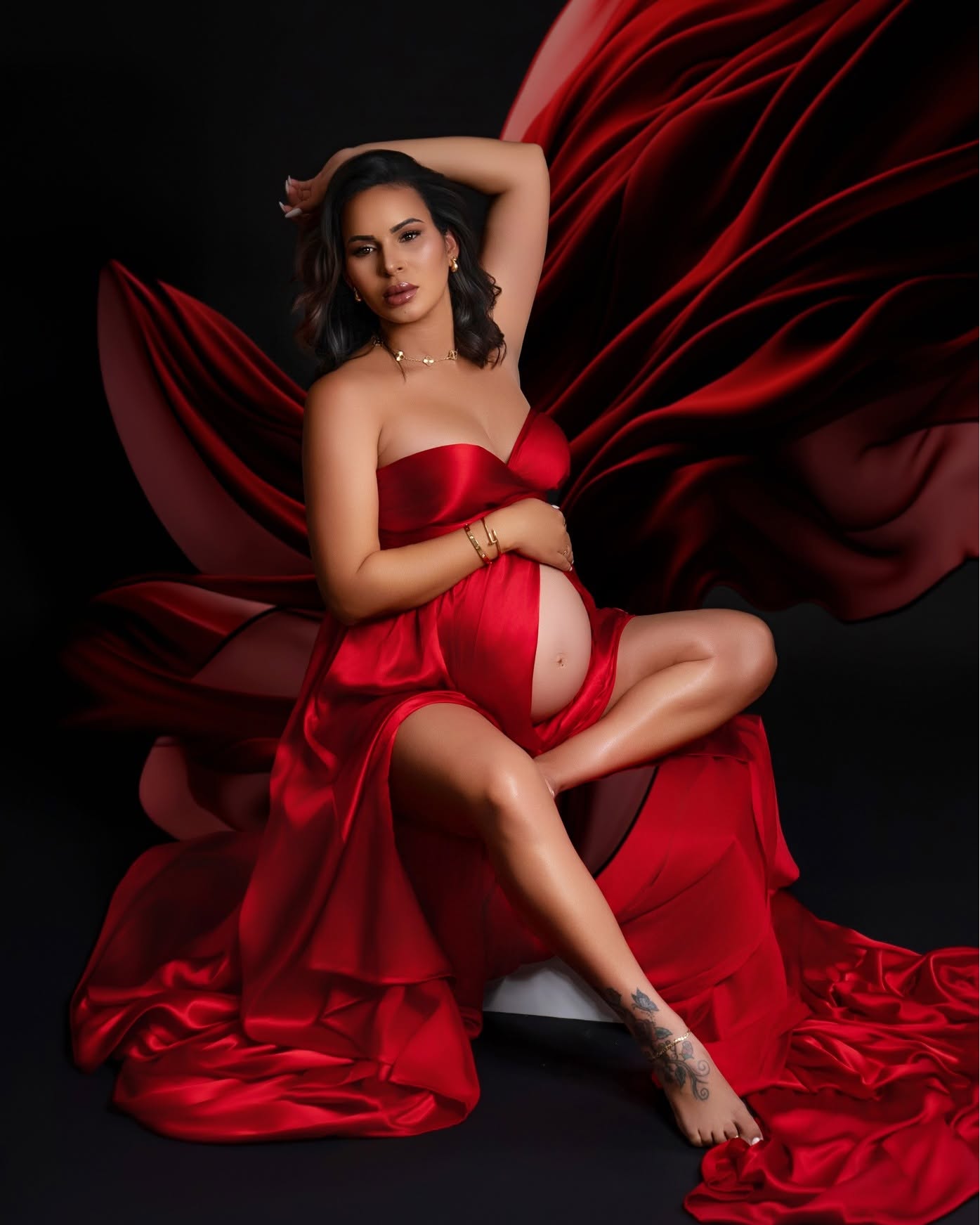 Retrato de maternidad en vestido rojo satinado