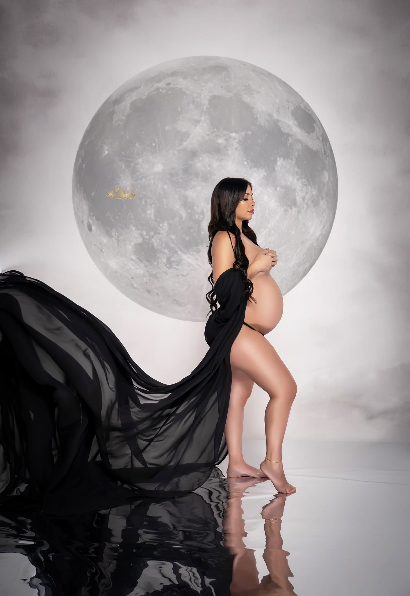 Retrato artístico de maternidad con luna y vestido negro