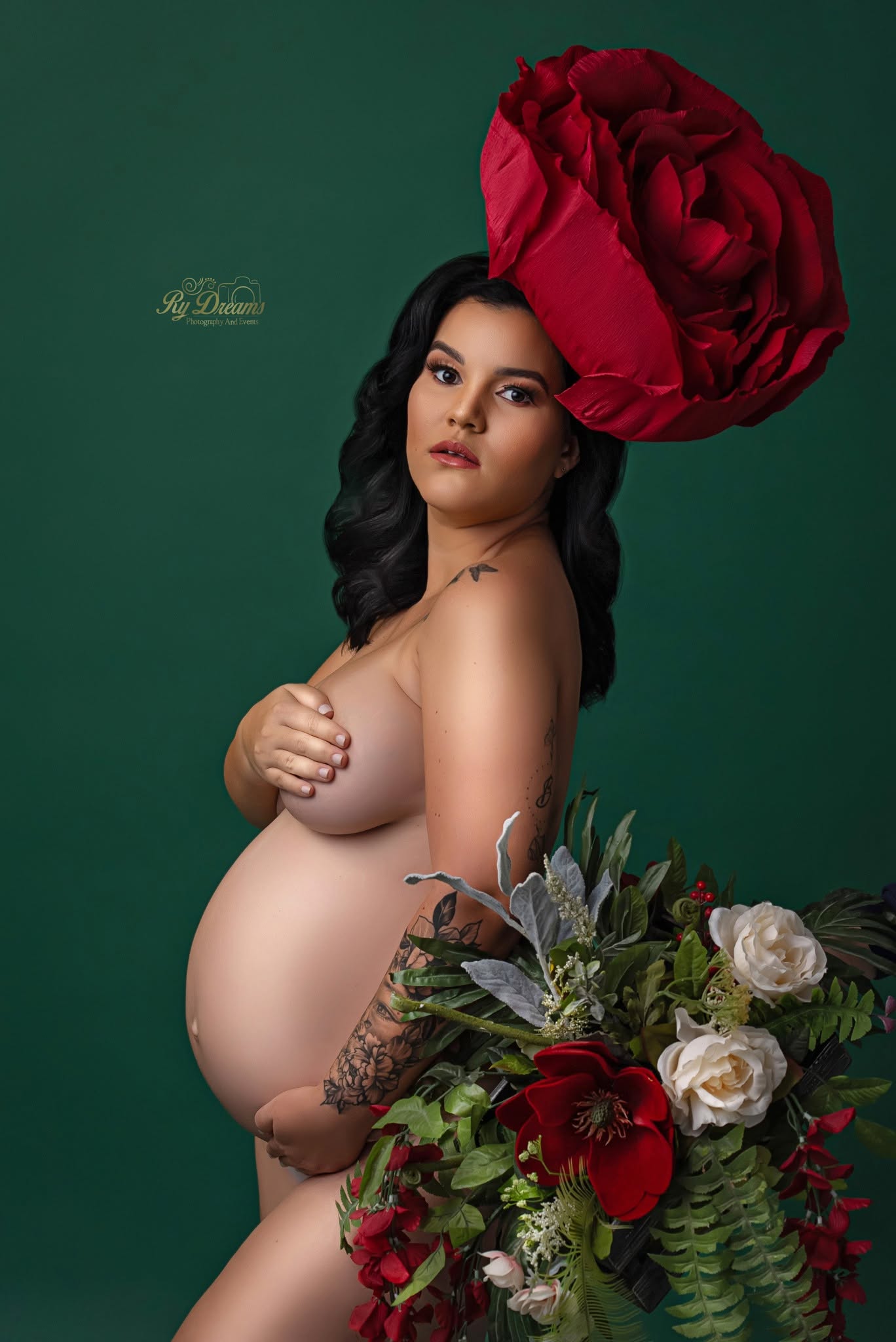Retrato de maternidad con fondo verde y tocado floral rojo