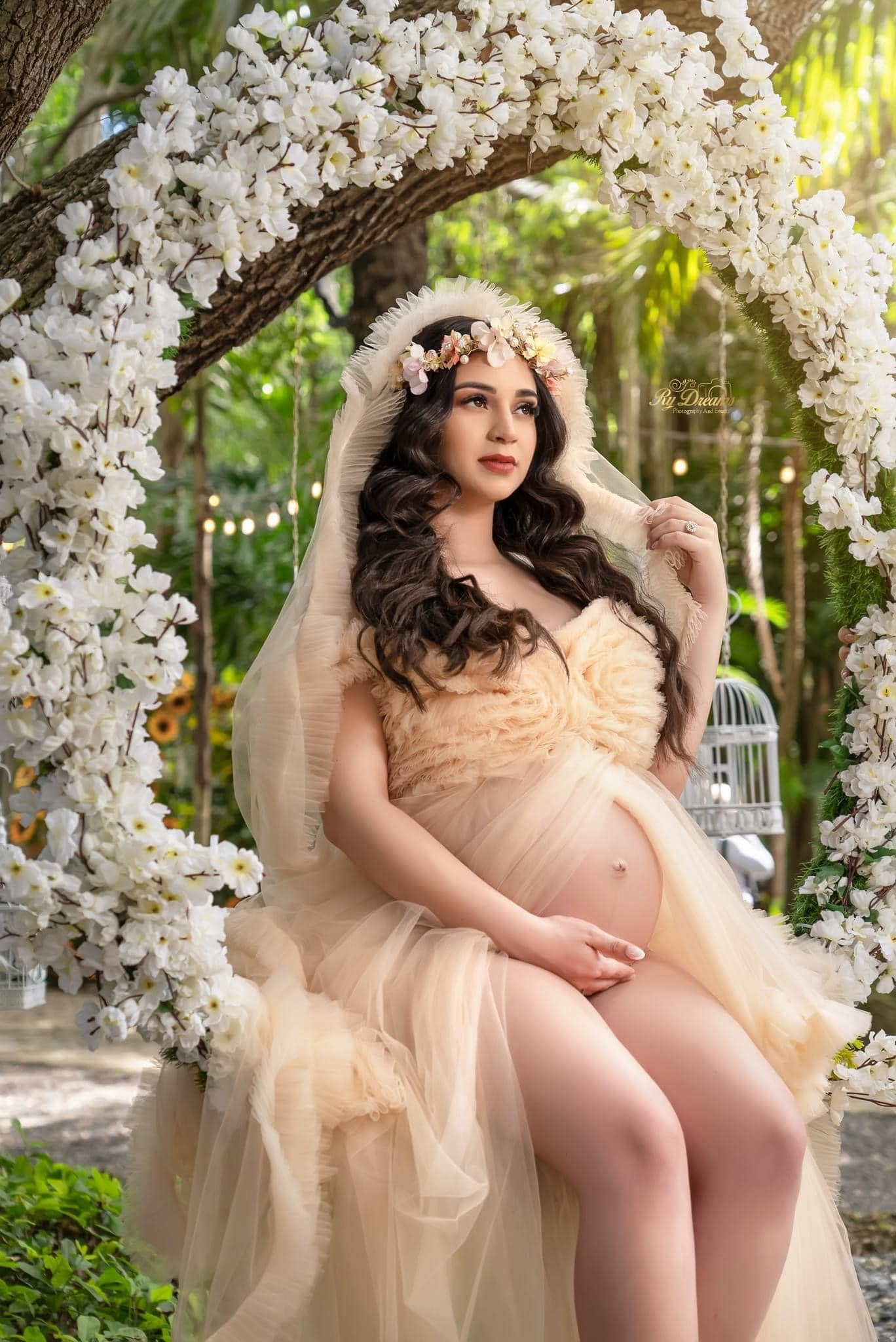 Retrato de maternidad en jardín con flores blancas