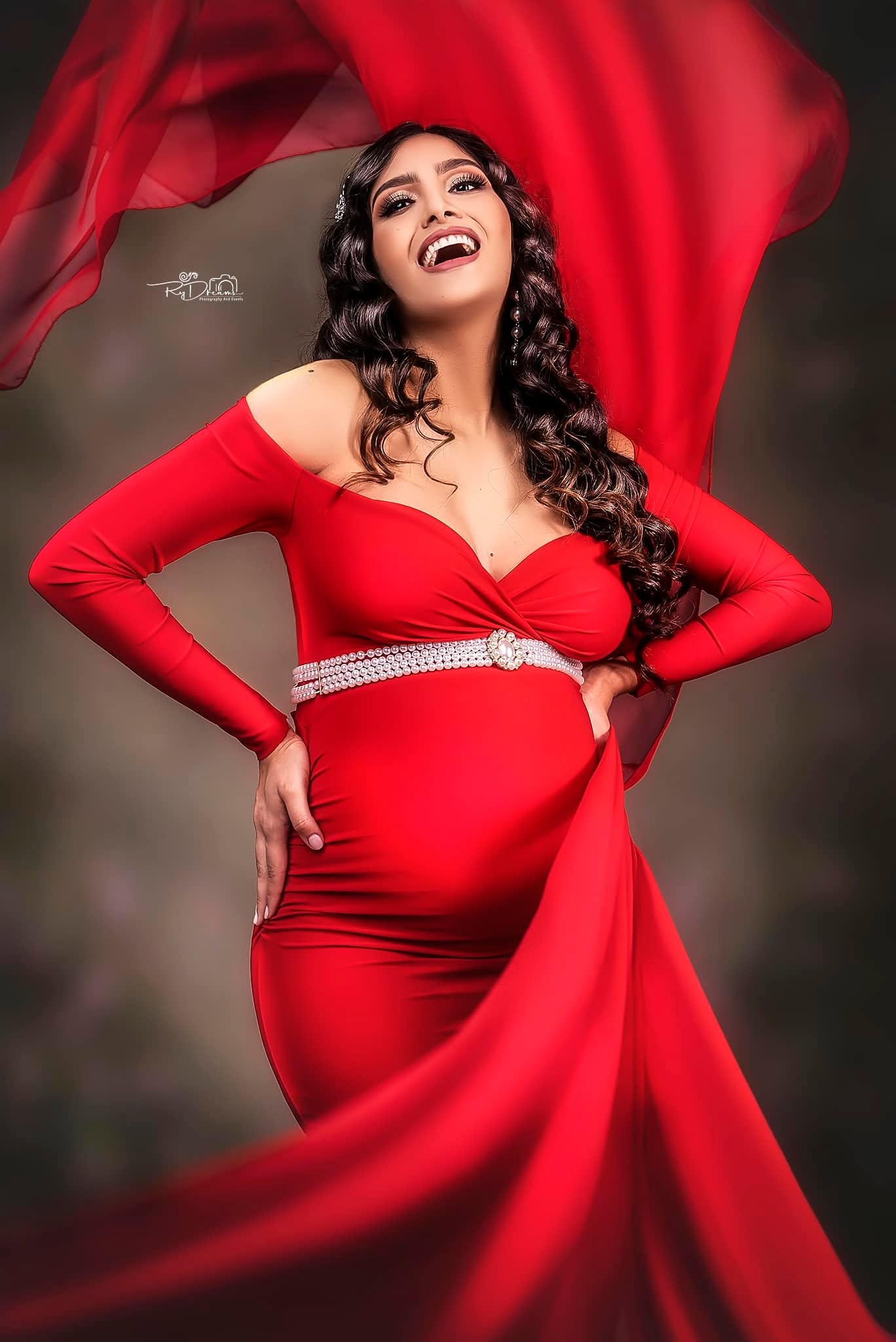 Retrato alegre de maternidad con vestido rojo