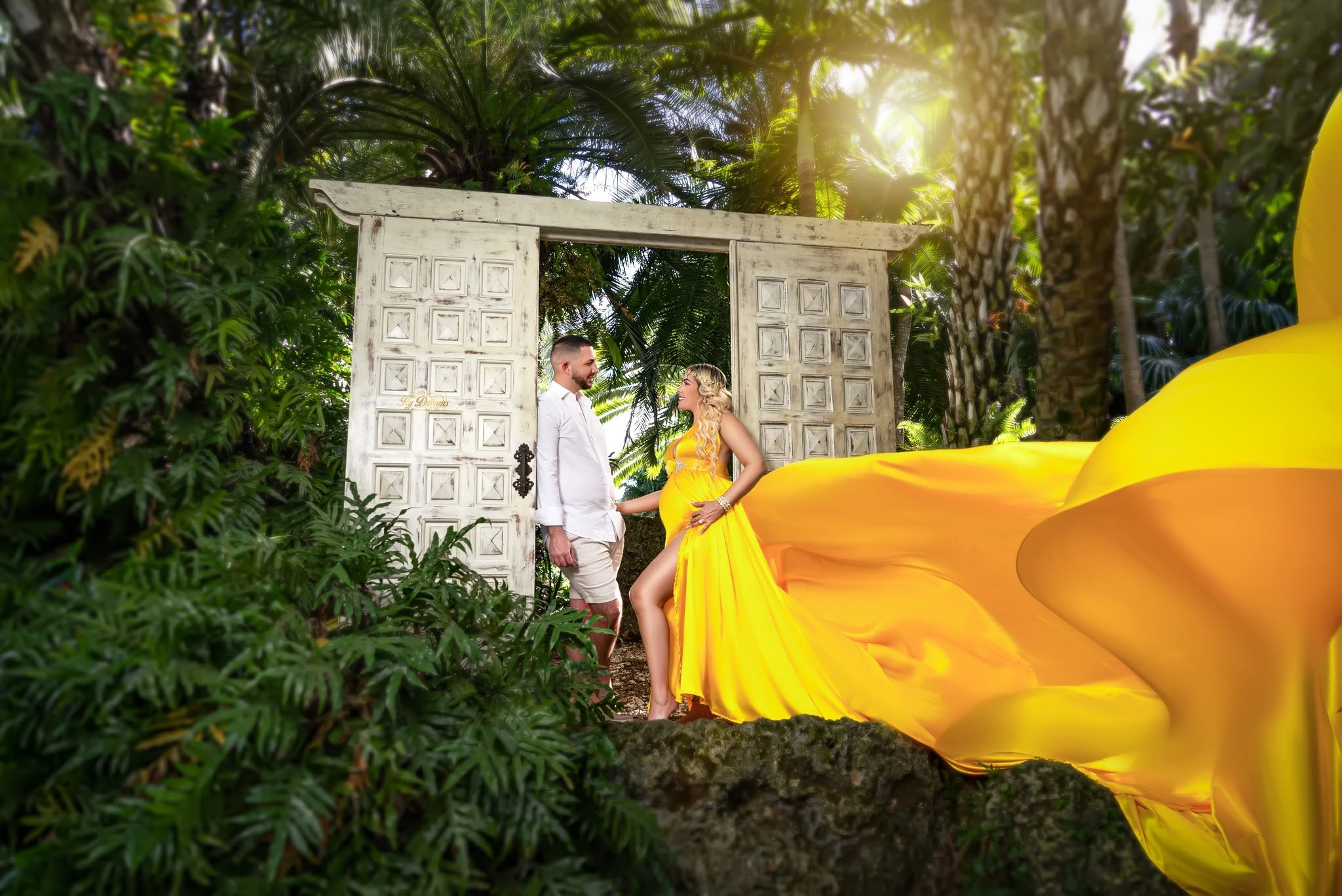 Maternidad en jardín tropical con vestido amarillo