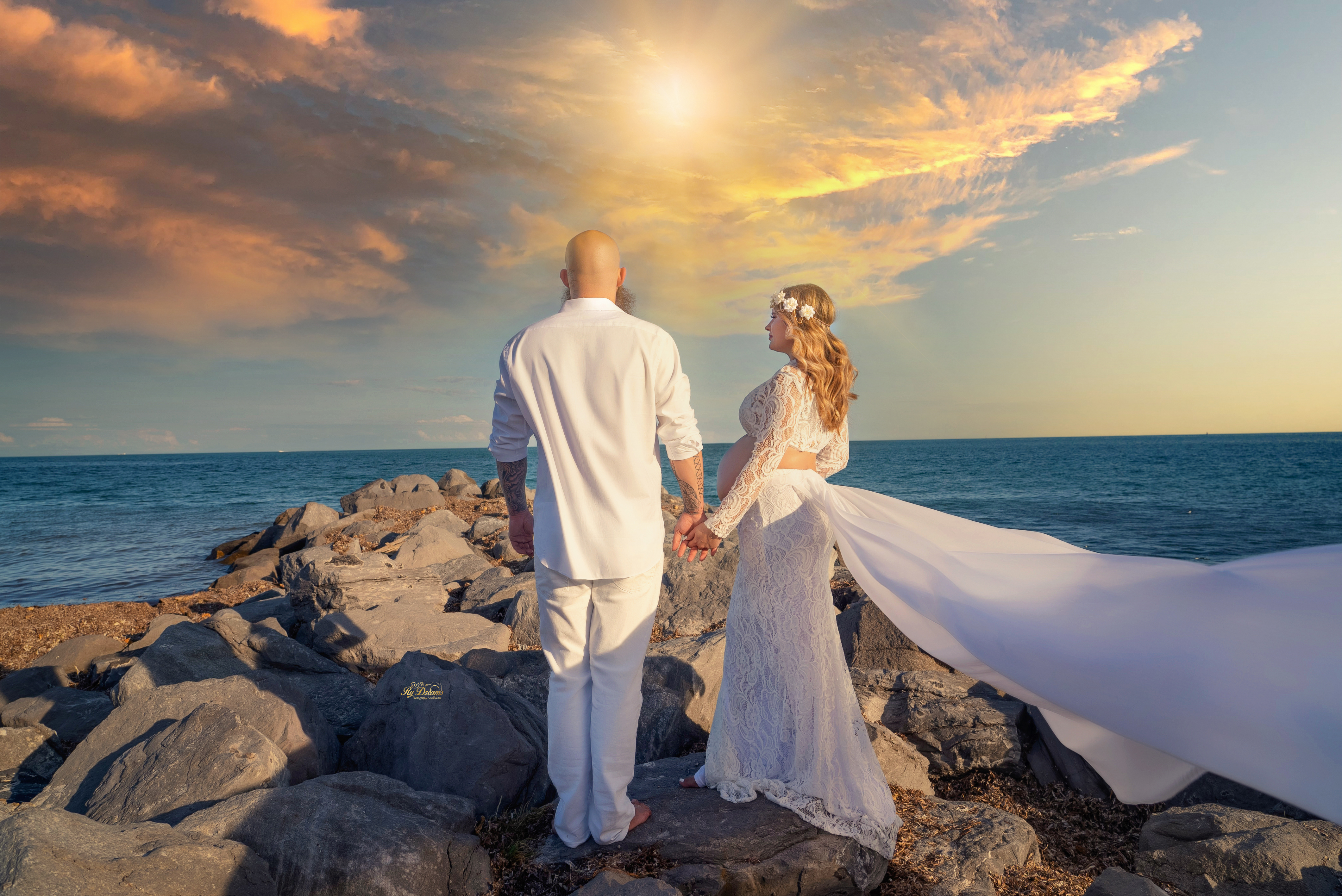 Sesión de maternidad en playa al atardecer con pareja